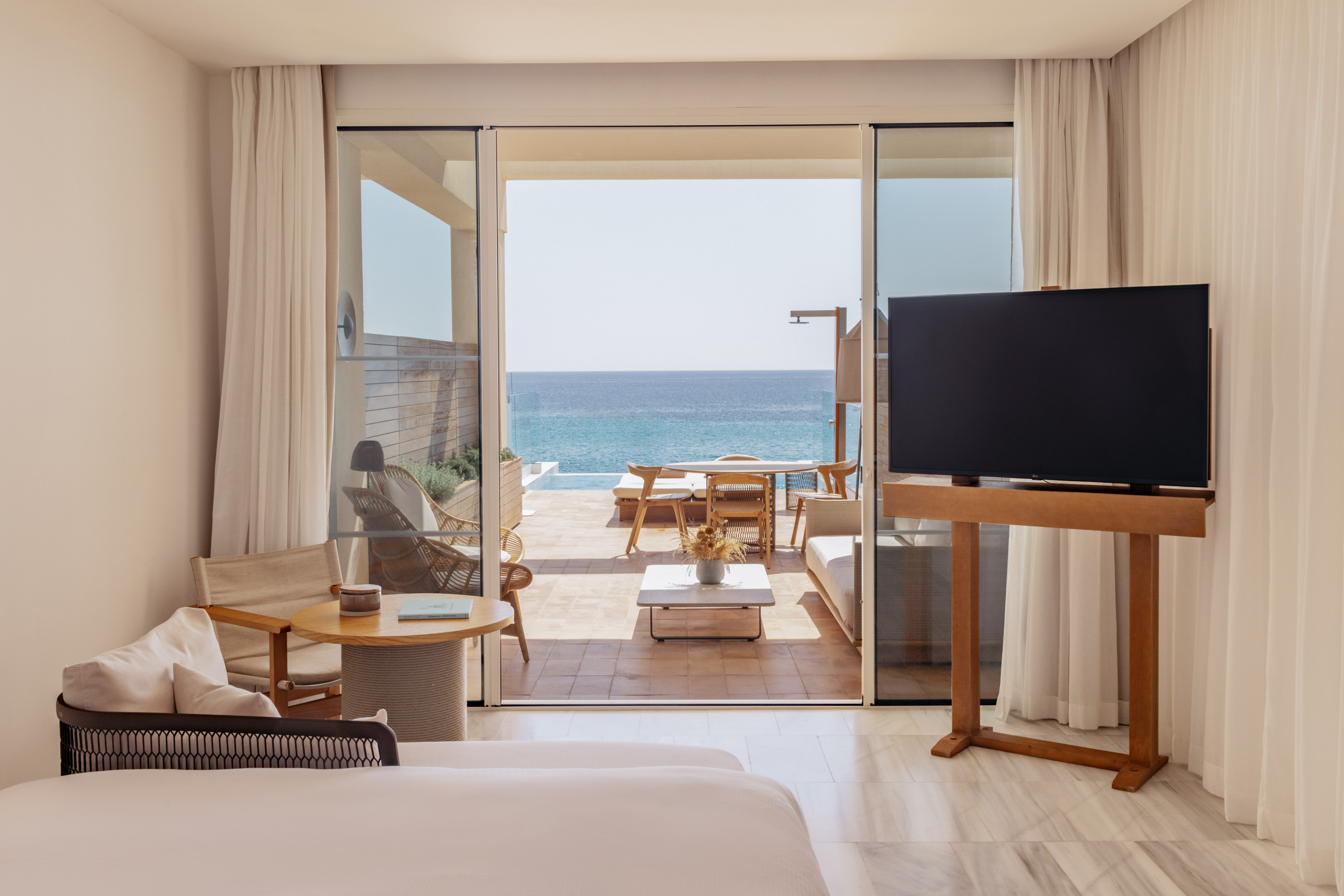 a room with a television and a view of the ocean