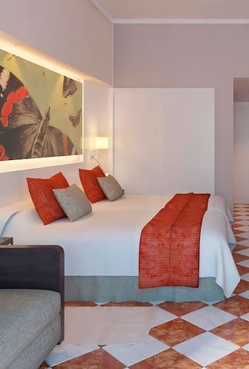 a bed with pillows and a painting on the wall