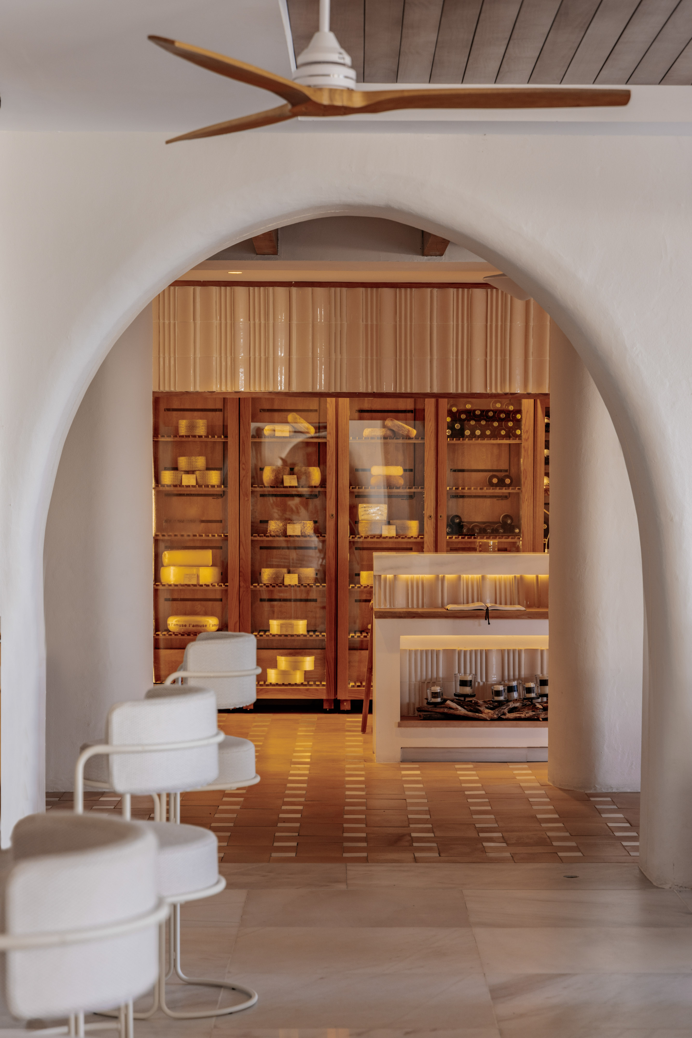 Arched white interior showing a gourmet cheese and wine display.
