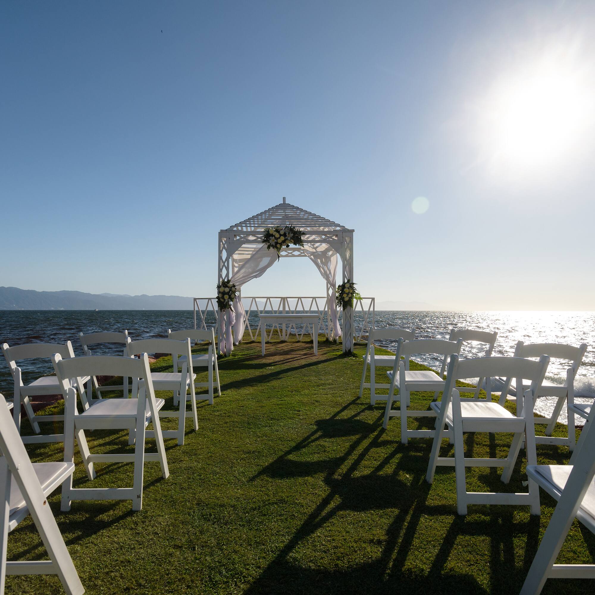 a wedding ceremony set up on a grassy area with white chairs
