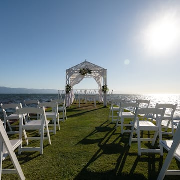 a wedding ceremony set up on a grassy area with white chairs