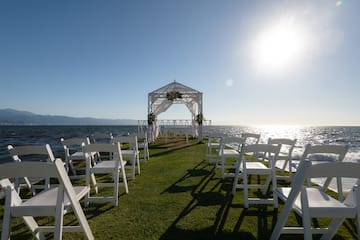 a wedding ceremony set up on a grassy area with white chairs