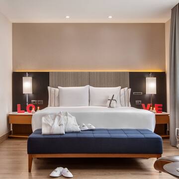 a bedroom with a bed and a blue ottoman