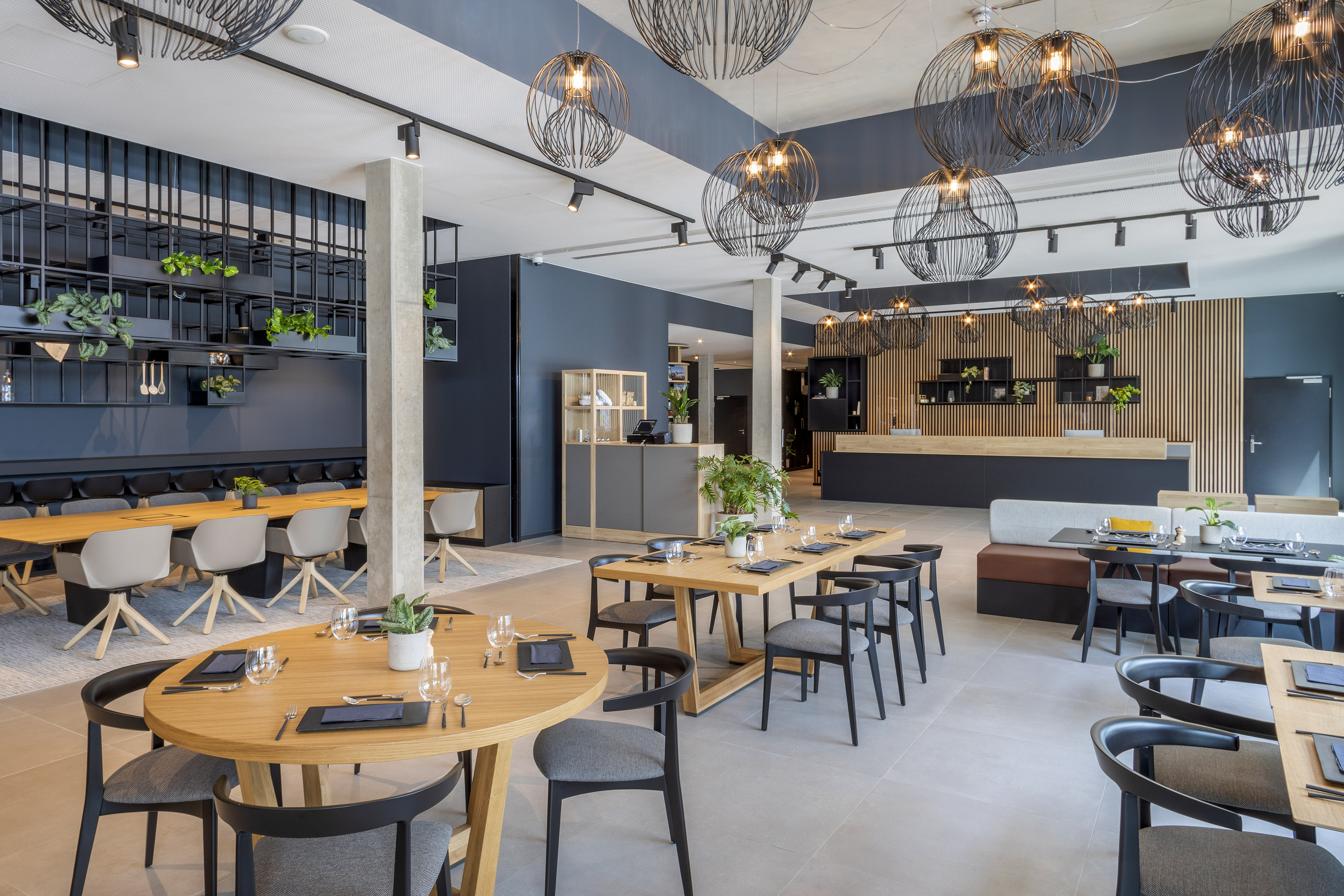 Modern restaurant dining: wooden tables, contemporary chairs, black wire lights. - De Gaart, Cocina local - INNSiDE Luxembourg, Luxemburgo