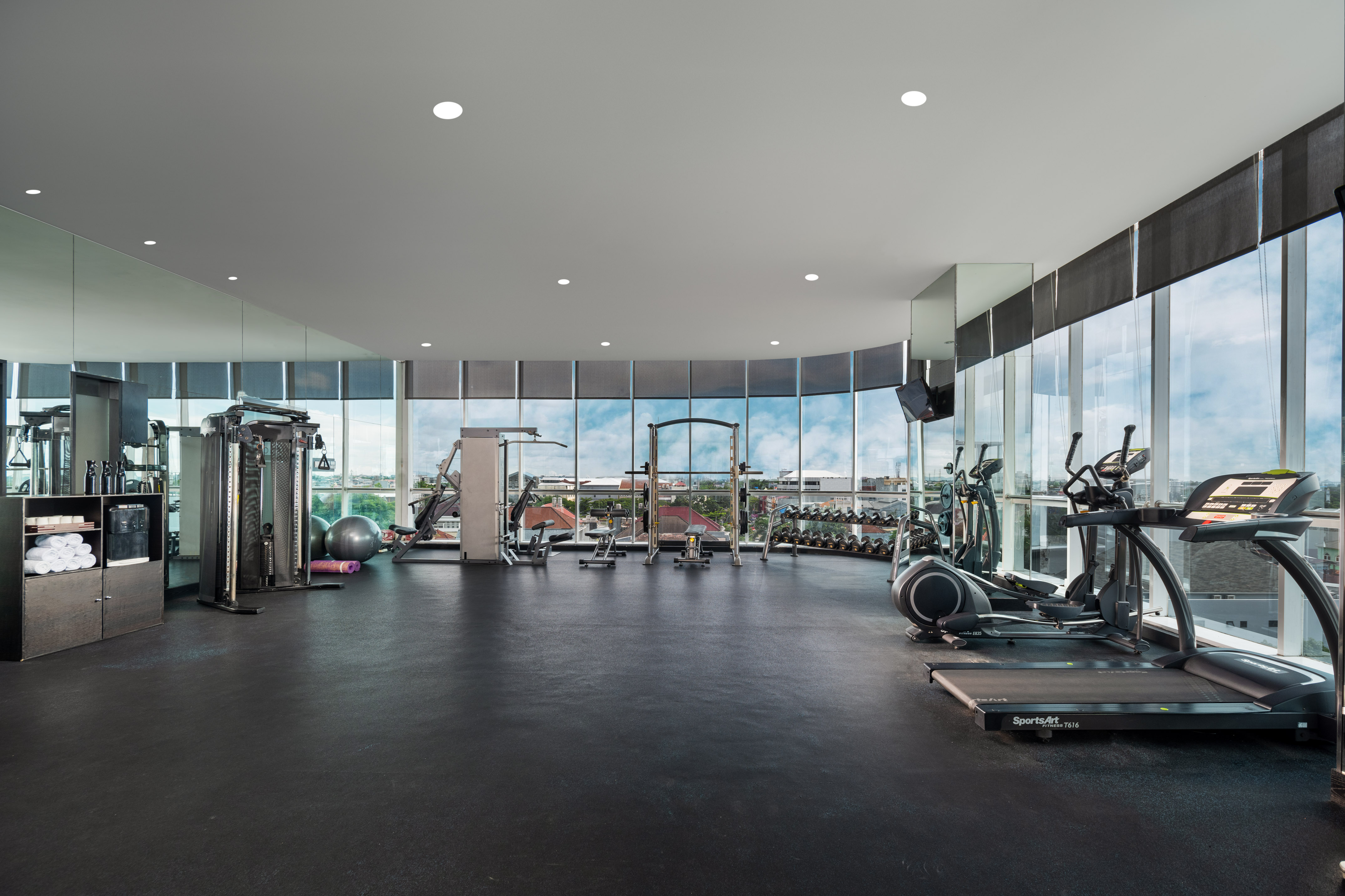 Spacious fitness center with exercise machines, weights, and city views.