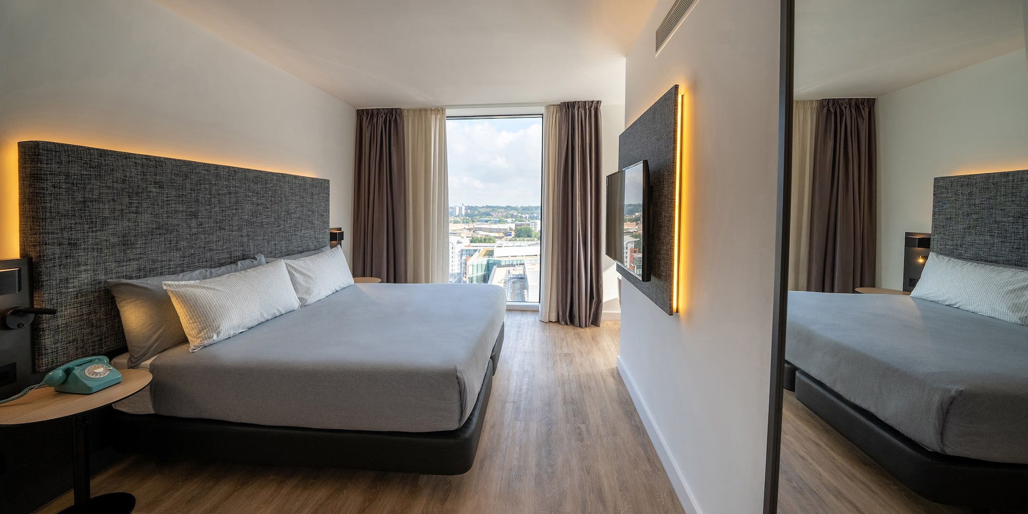 a bedroom with a large mirror and a large bed