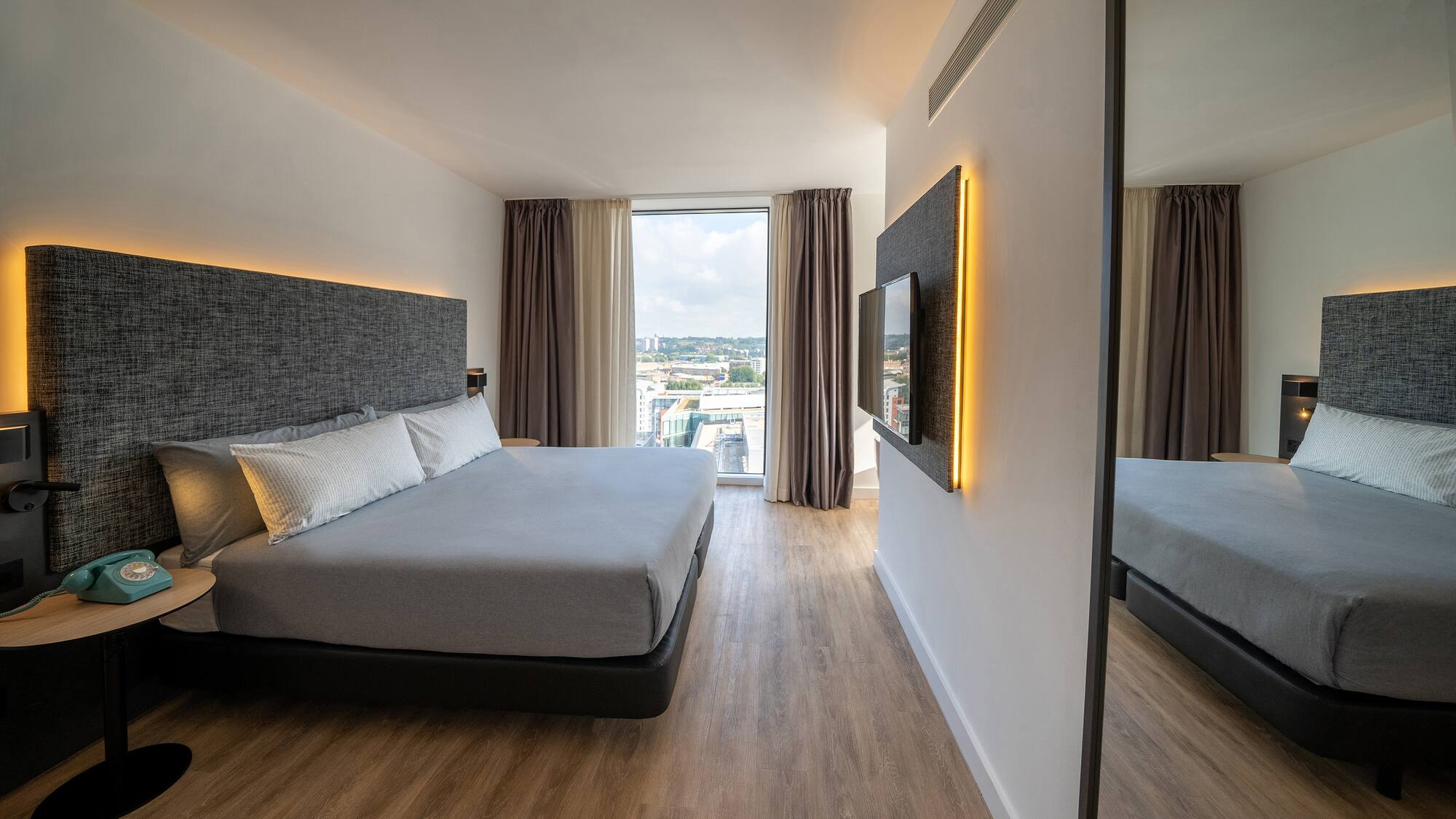 a bedroom with a large mirror and a large bed