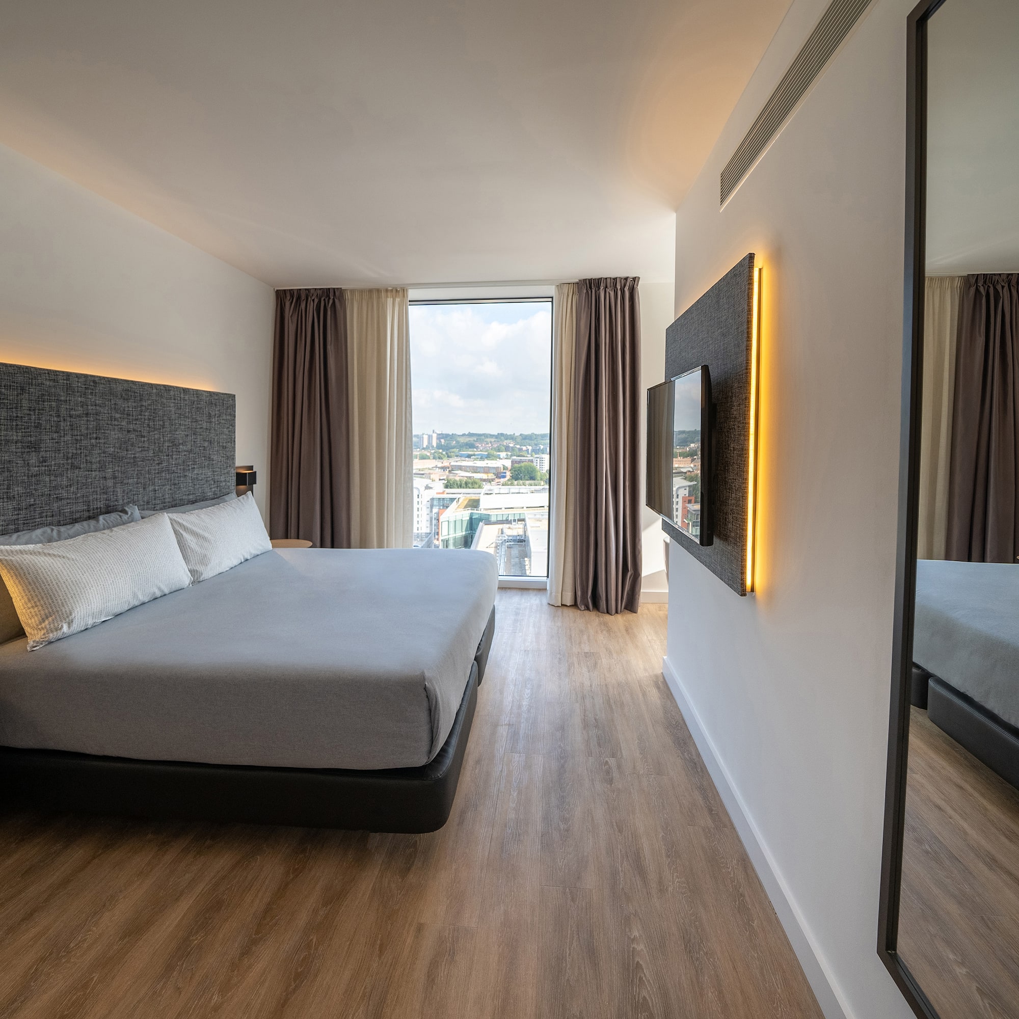 a bedroom with a large mirror and a large bed