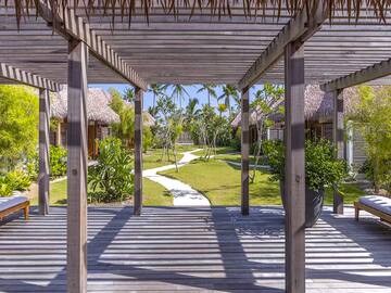 a wooden deck with a walkway and grass covered walkway