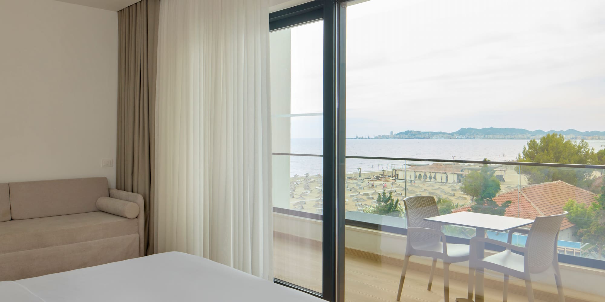 a room with a view of the ocean and a table and chairs