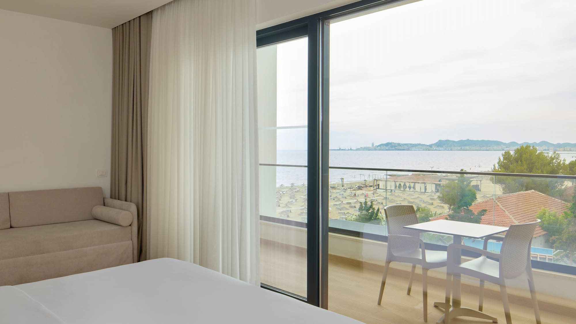 a room with a view of the ocean and a table and chairs