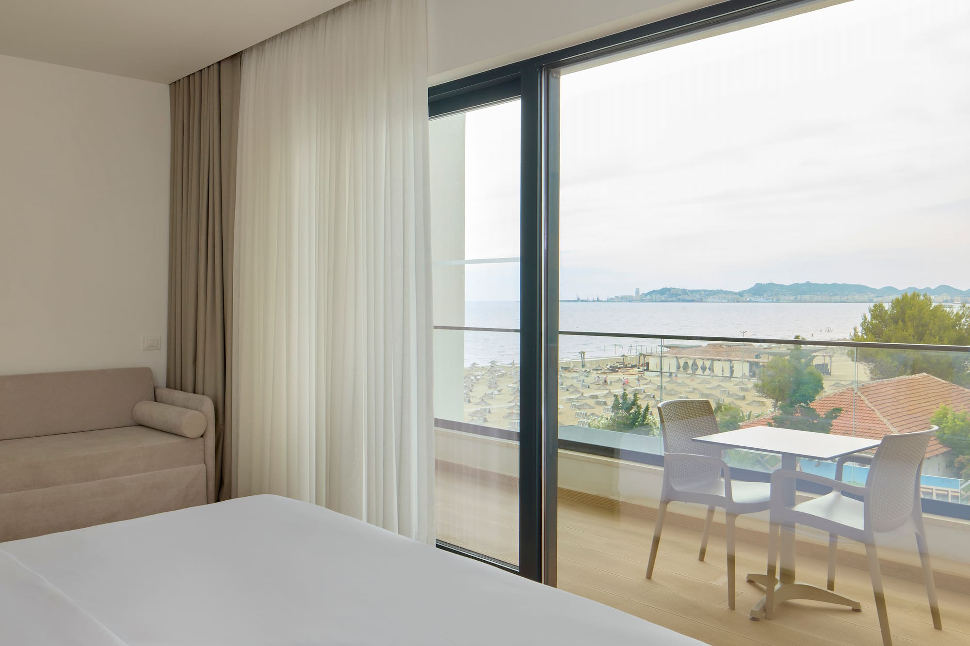 a room with a view of the ocean and a table and chairs