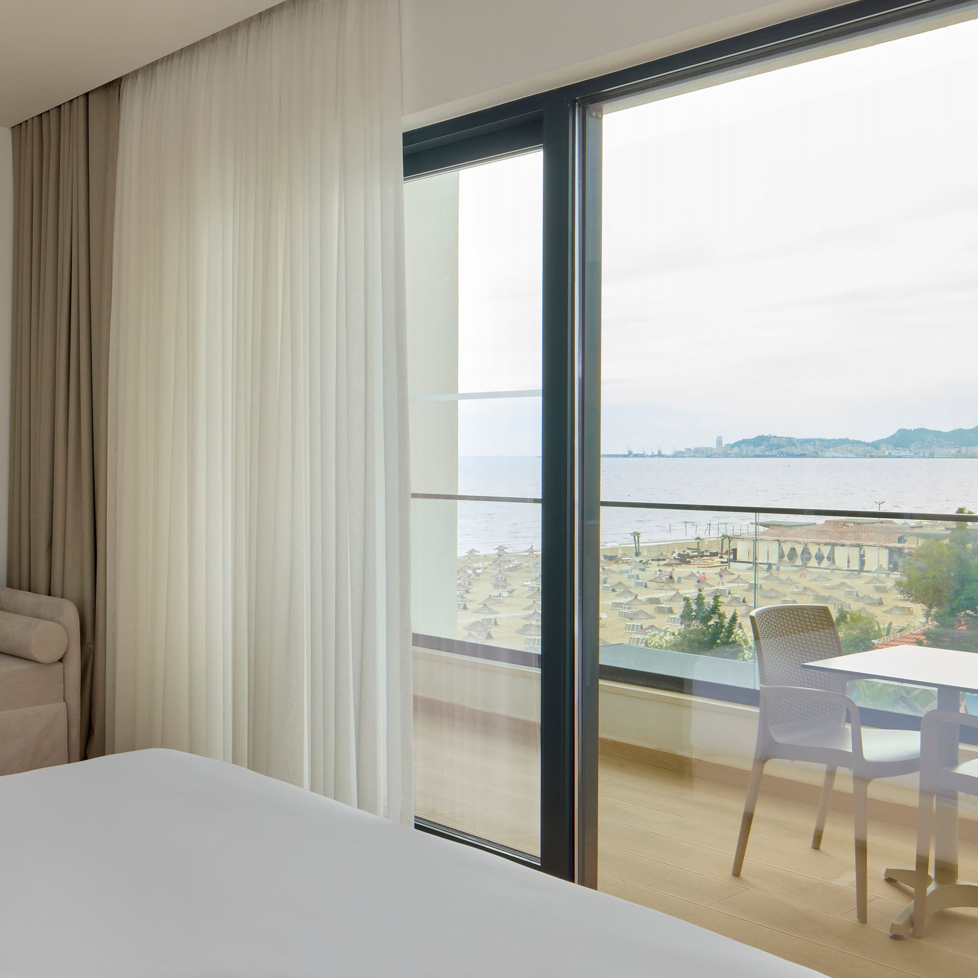 a room with a view of the ocean and a table and chairs