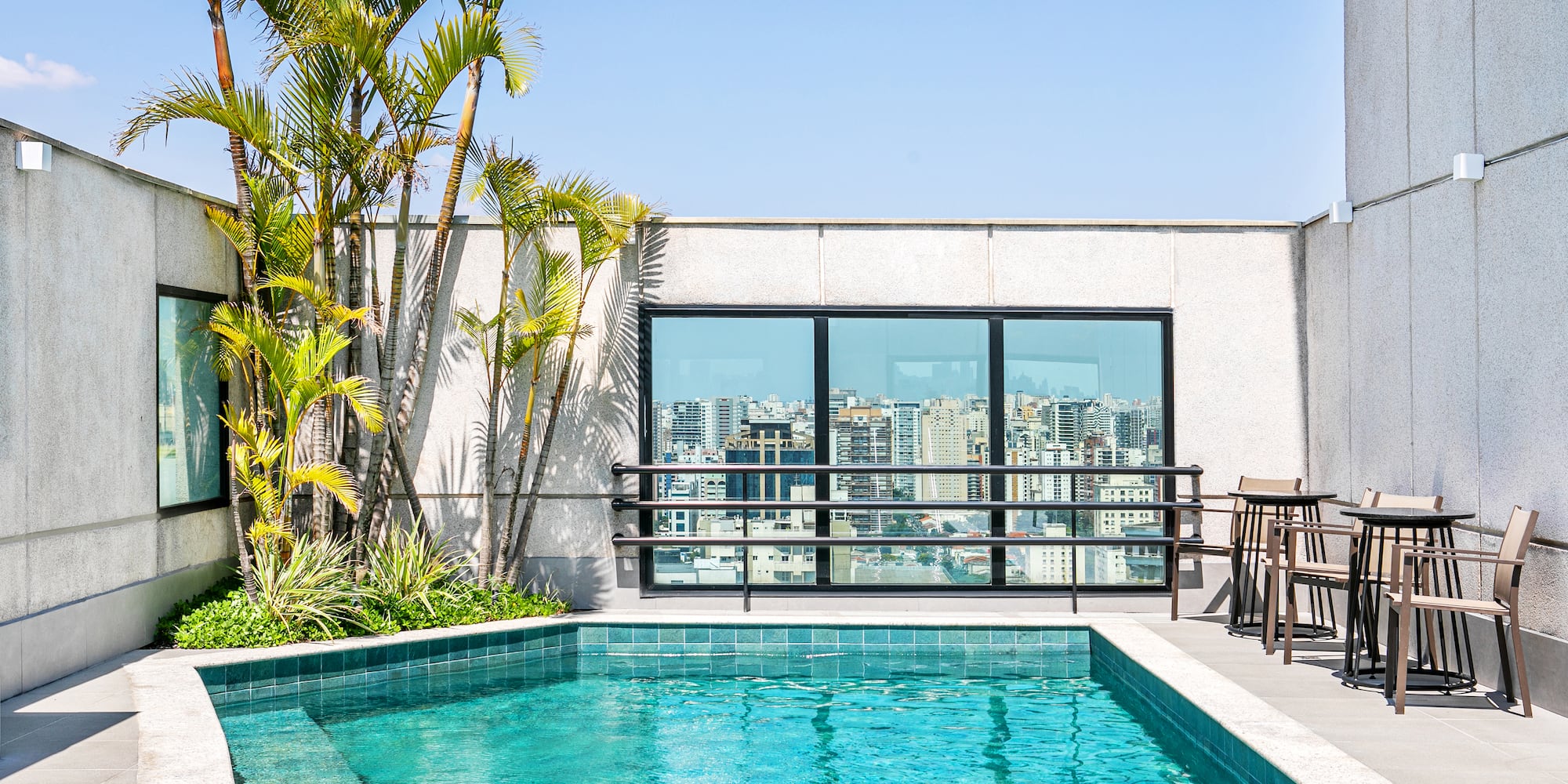 a pool with chairs and a table next to a building