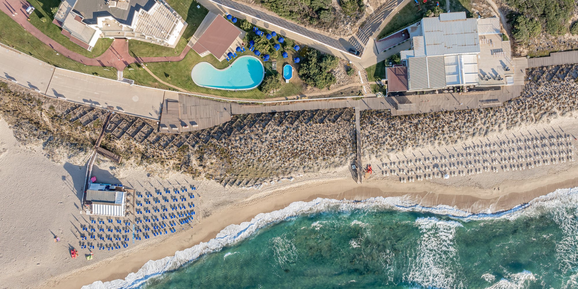 aerial view of a beach with a swimming pool and houses