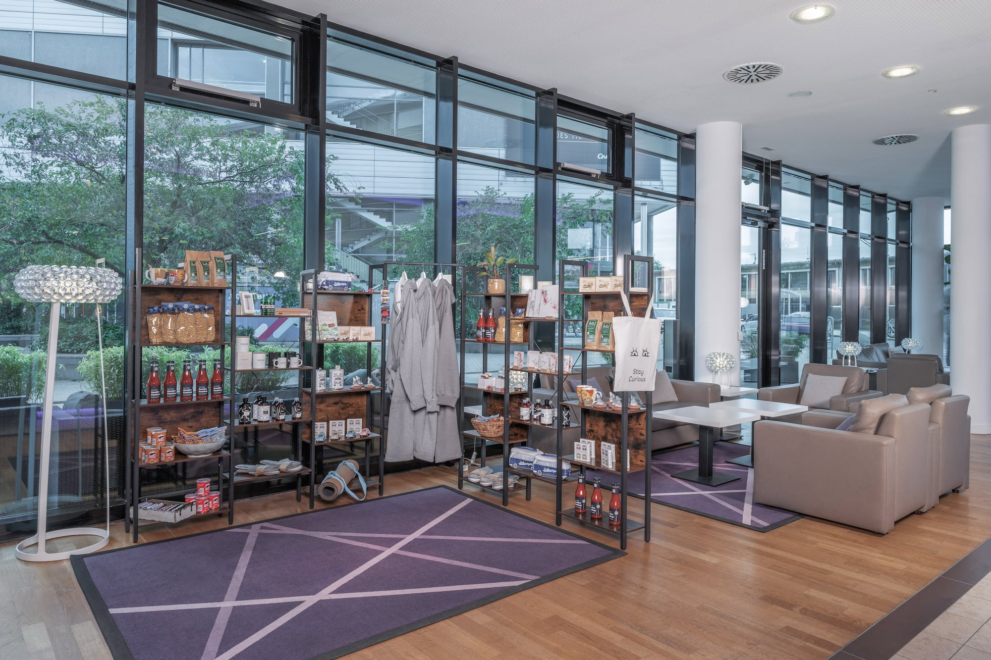 Hotel lobby retail shop with merchandise and lounge seating.