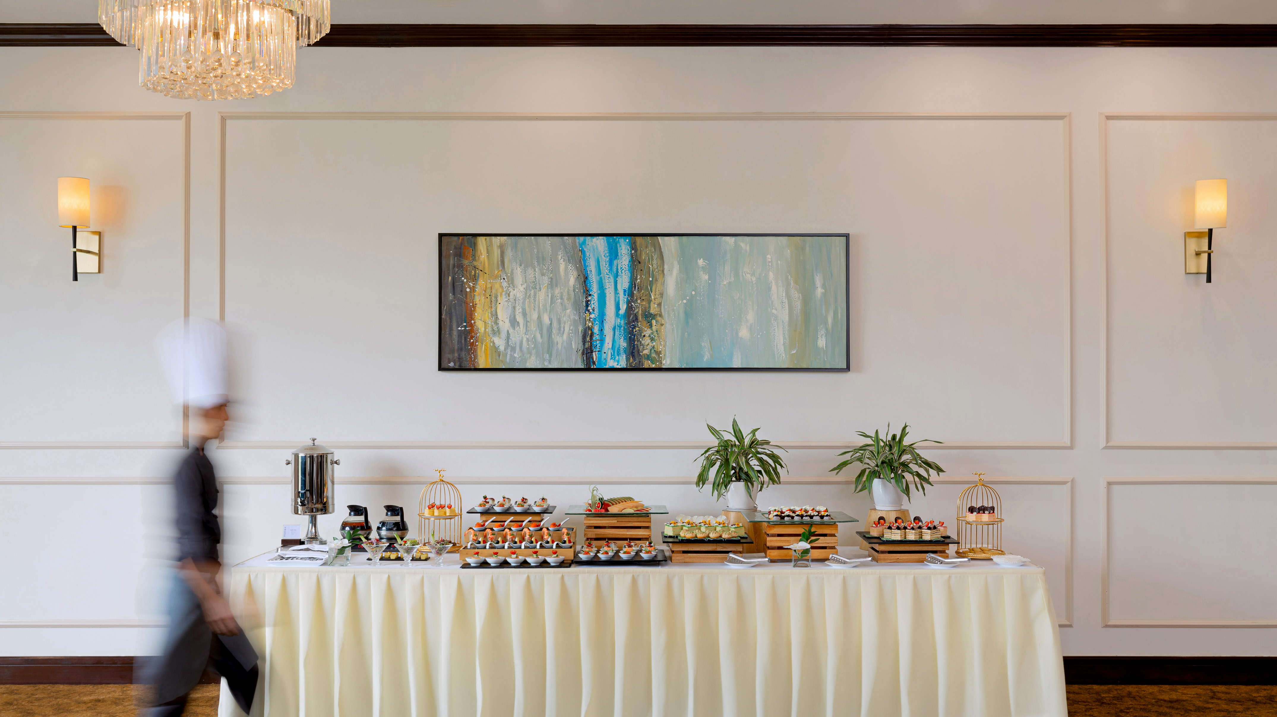 Elegant catering buffet with assorted appetizers, chef passing by.