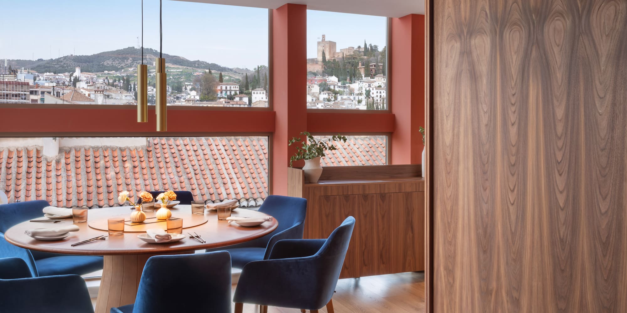 Modern dining room with panoramic Granada view, Alhambra, blue velvet chairs.