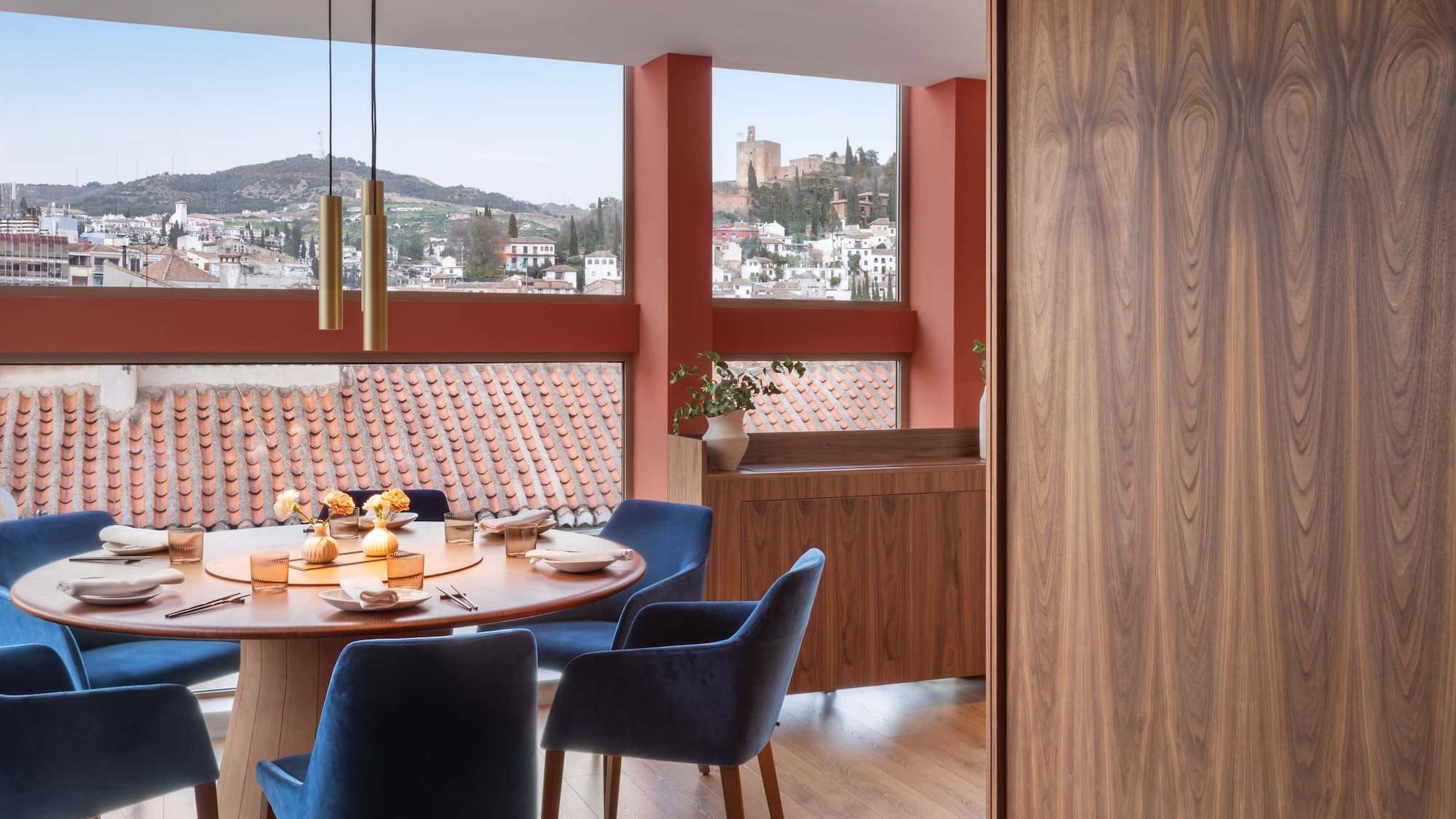 Modern dining room with panoramic Granada view, Alhambra, blue velvet chairs.