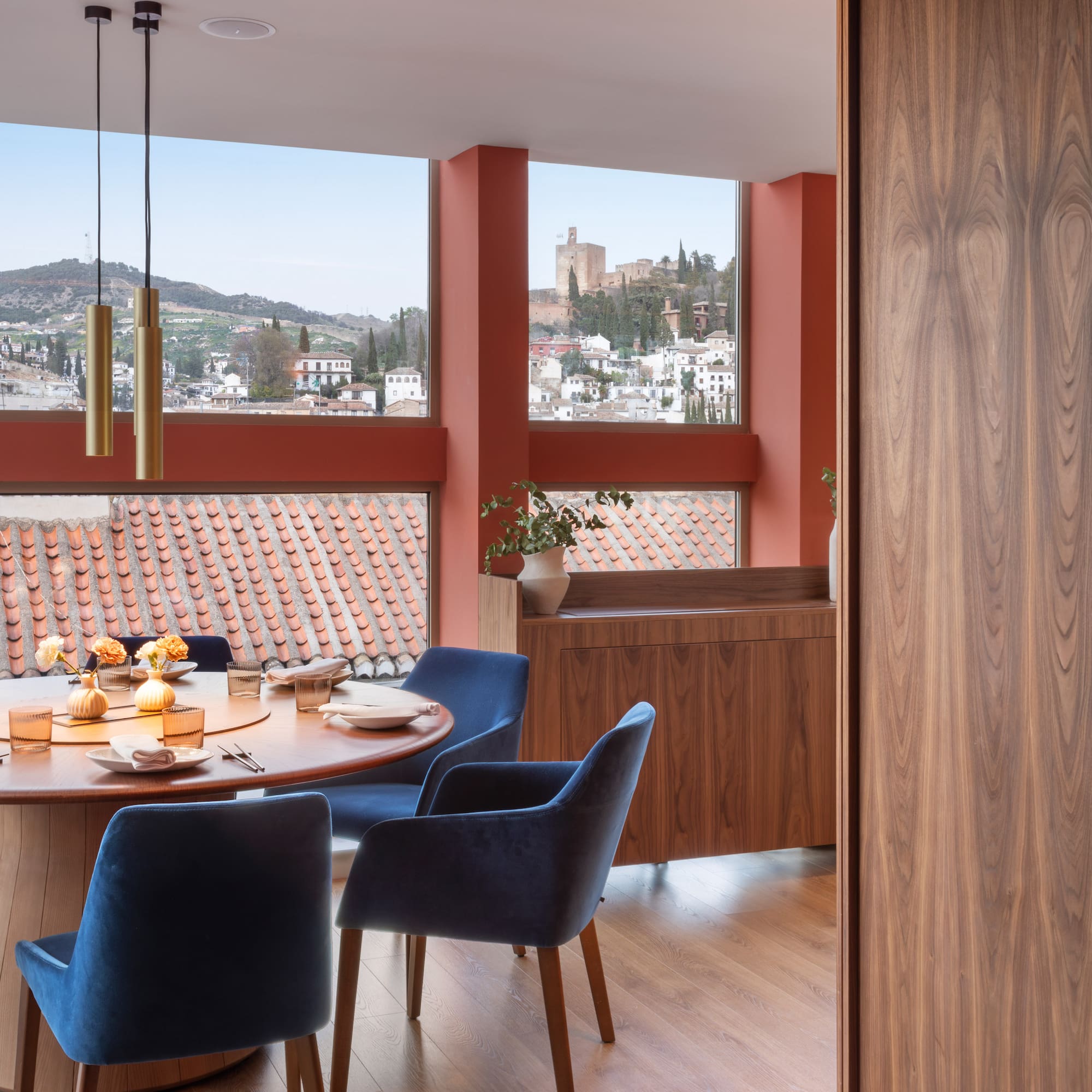 Modern dining room with panoramic Granada view, Alhambra, blue velvet chairs.