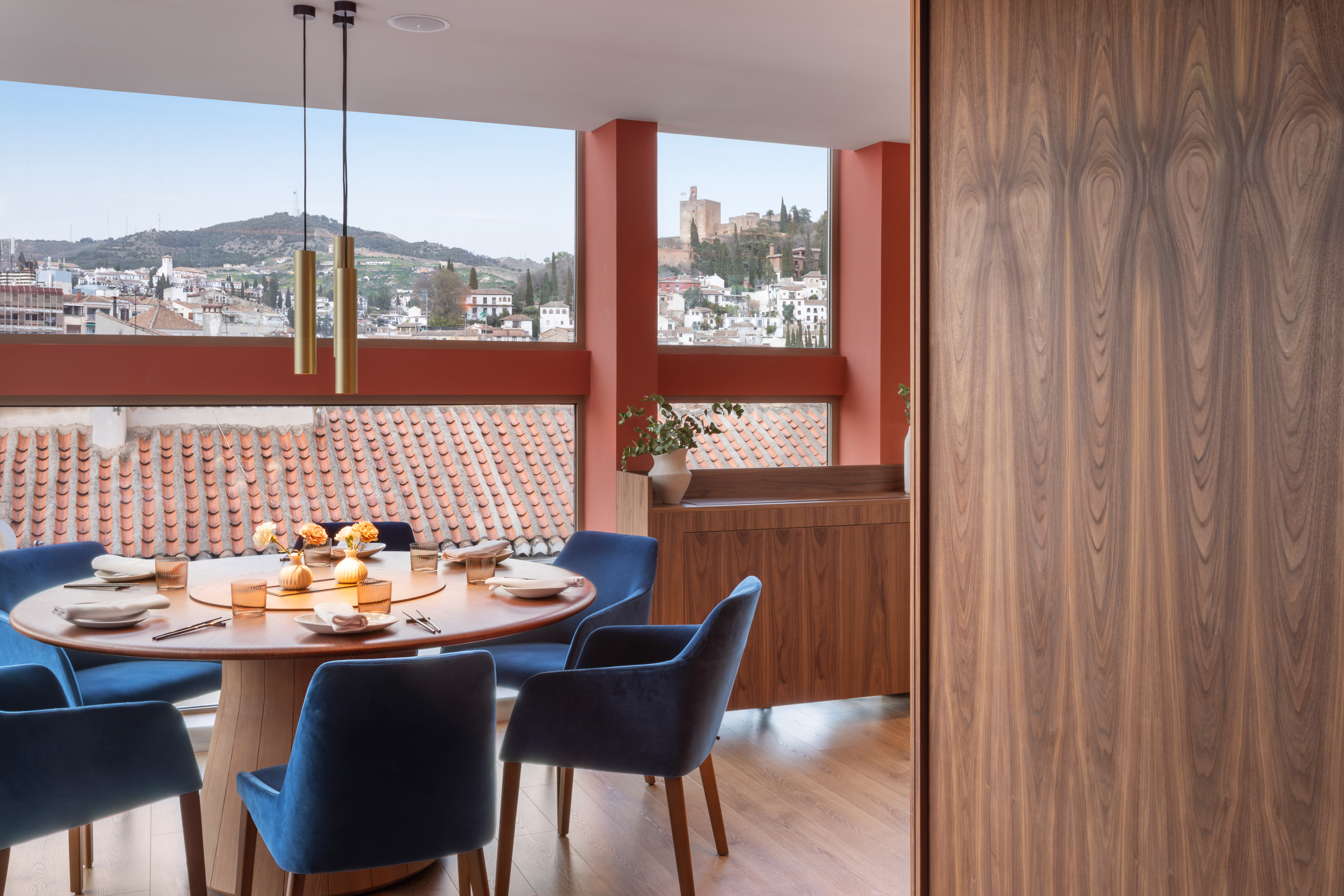 Modern dining room with panoramic Granada view, Alhambra, blue velvet chairs.