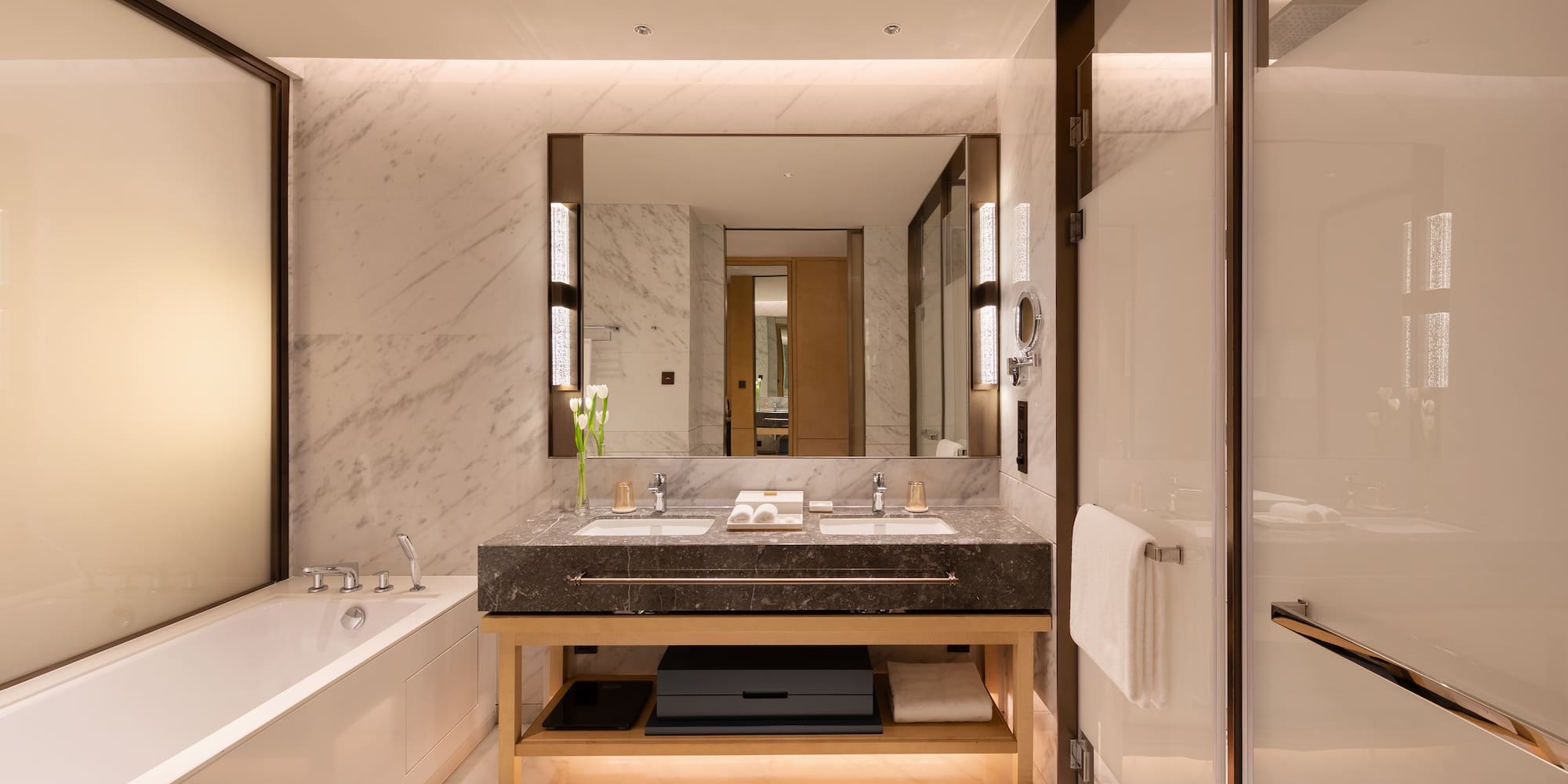 a bathroom with marble walls and a large mirror