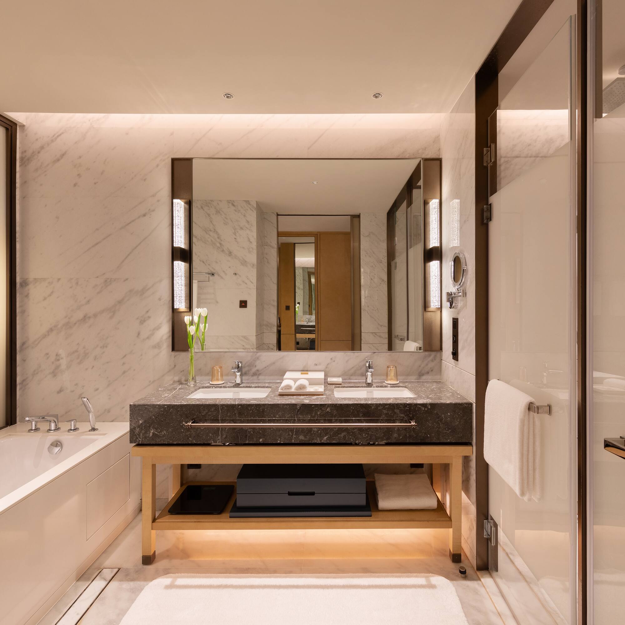 a bathroom with marble walls and a large mirror