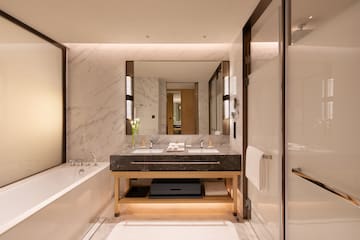 a bathroom with marble walls and a large mirror