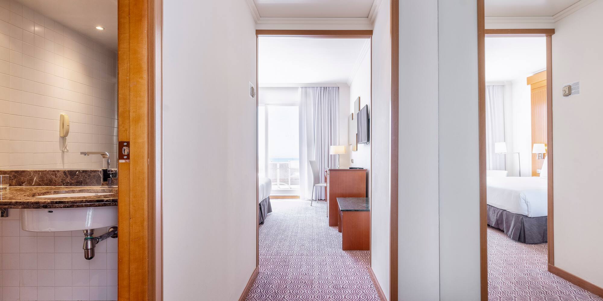 a hallway with a bed and a sink