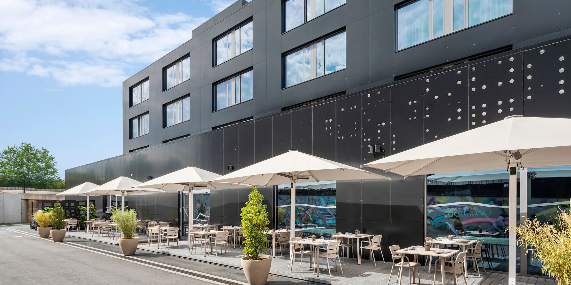 a building with tables and umbrellas