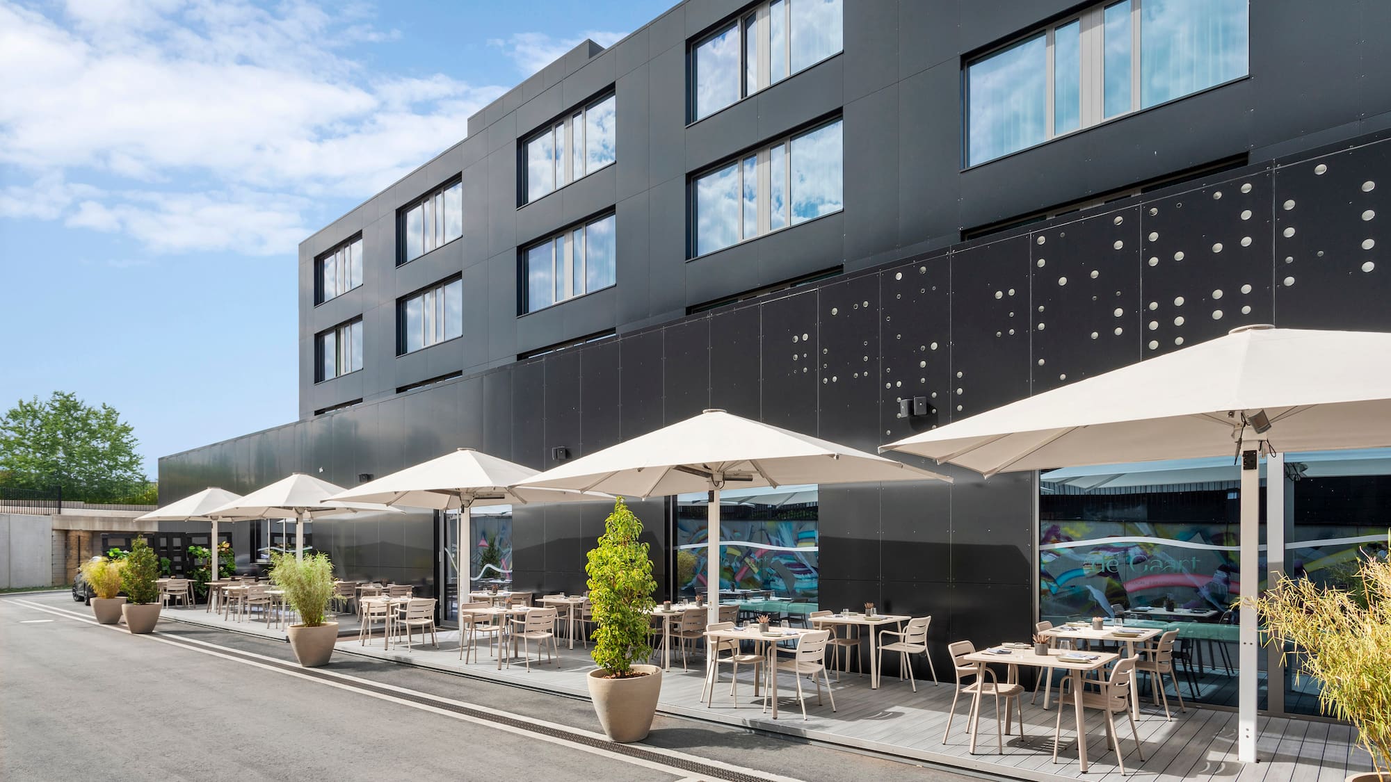 a building with tables and umbrellas
