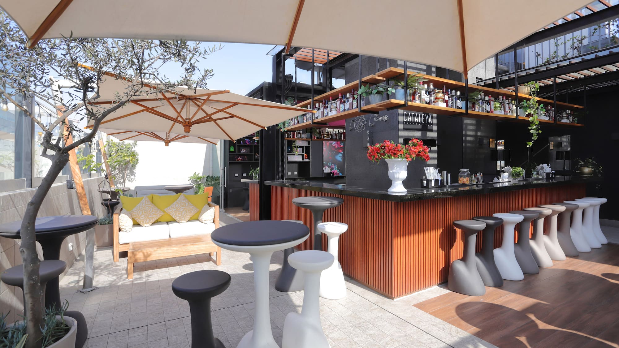 a bar with white tables and umbrellas