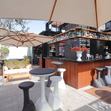 a bar with white tables and umbrellas
