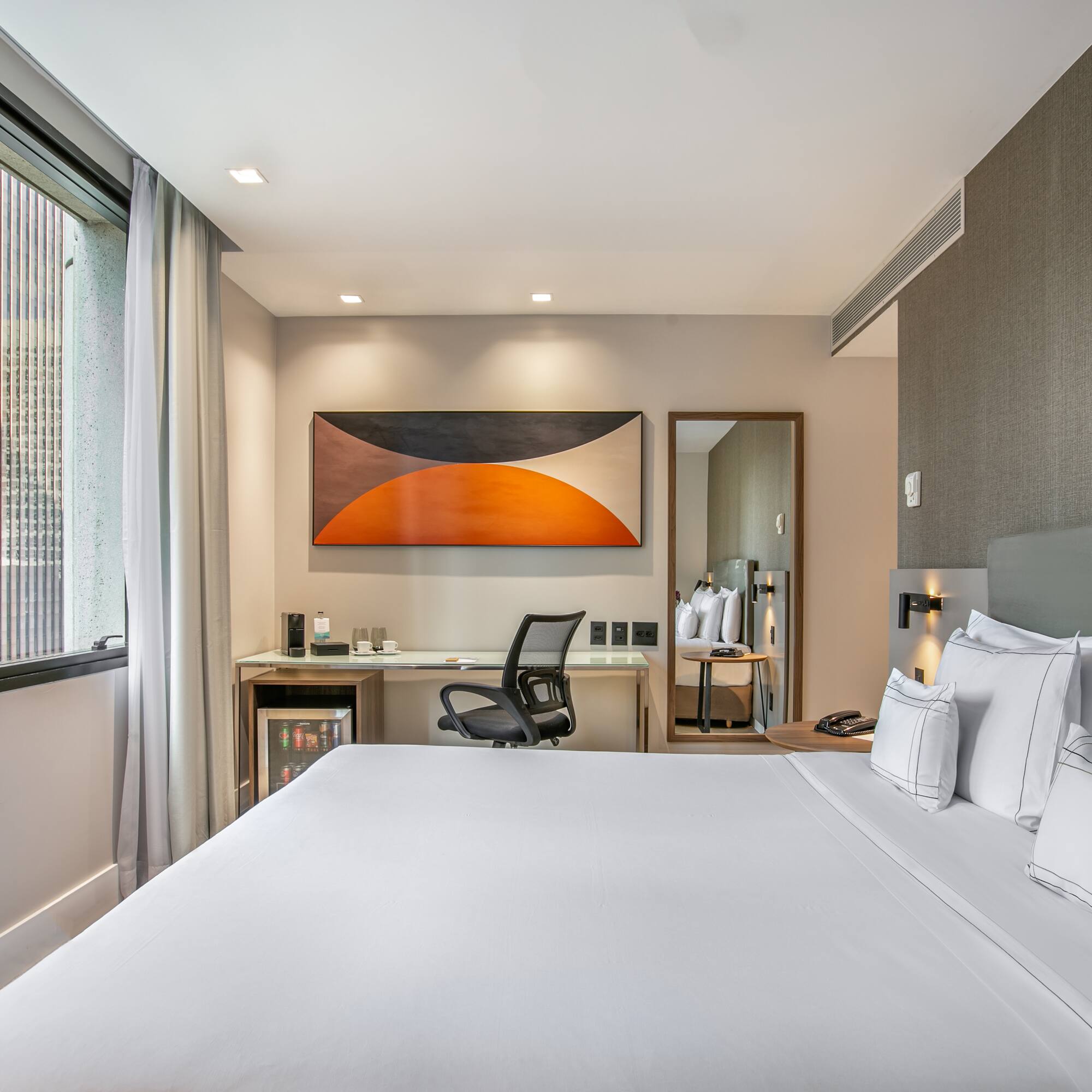 a bed with white sheets and a chair in a room