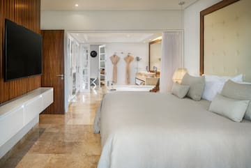 a bedroom with a large bed and a bathtub