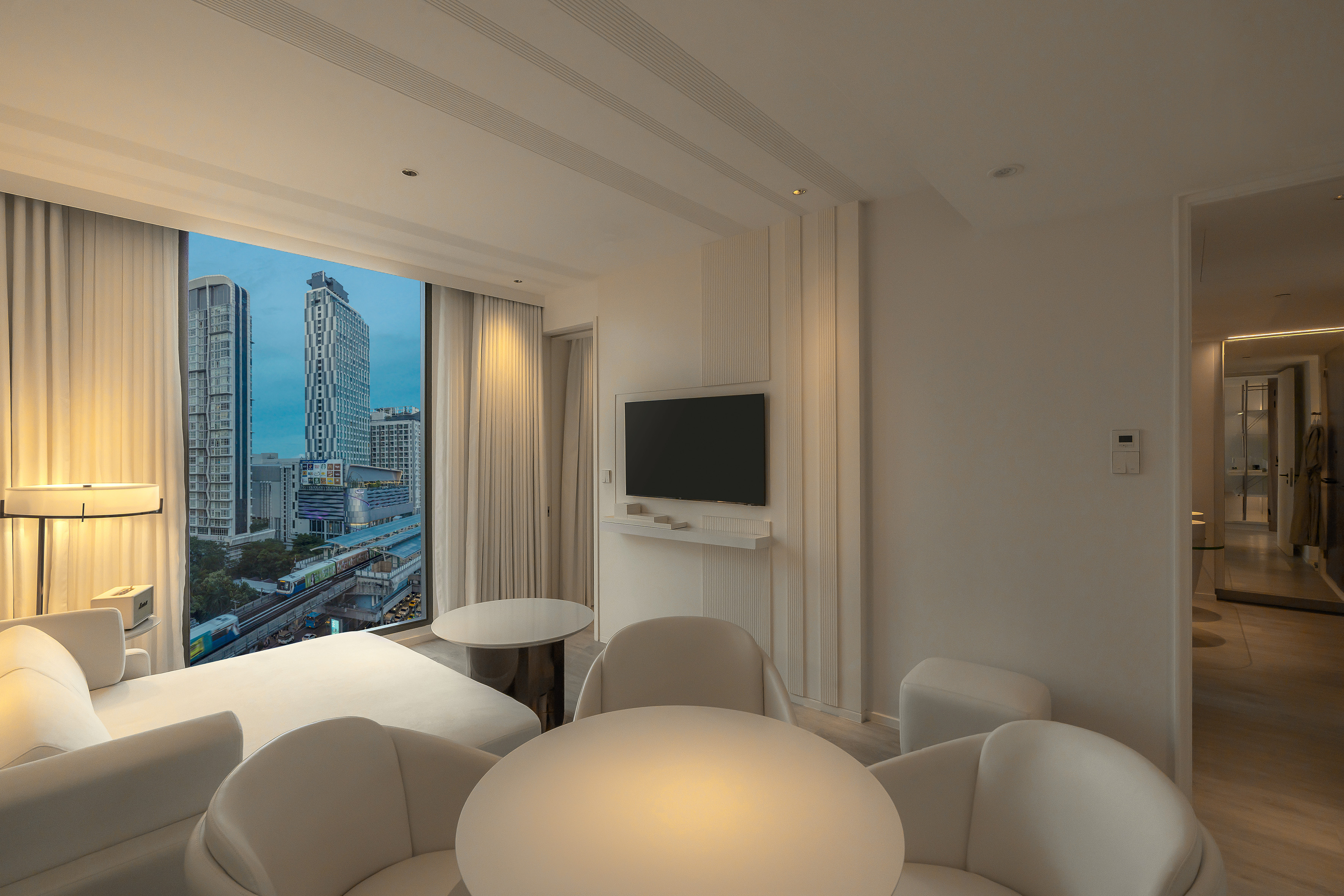 Minimalist hotel room overlooking Bangkok city and Skytrain.