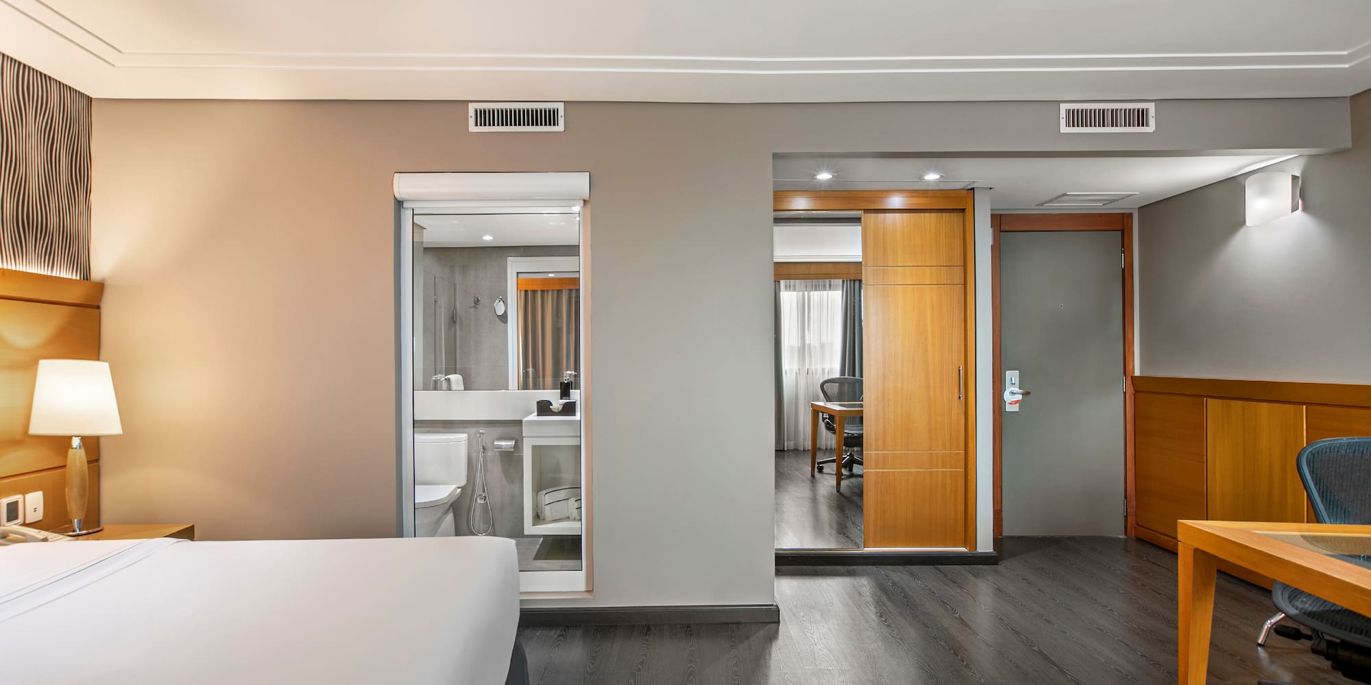 a bedroom with a wood floor and a wood door