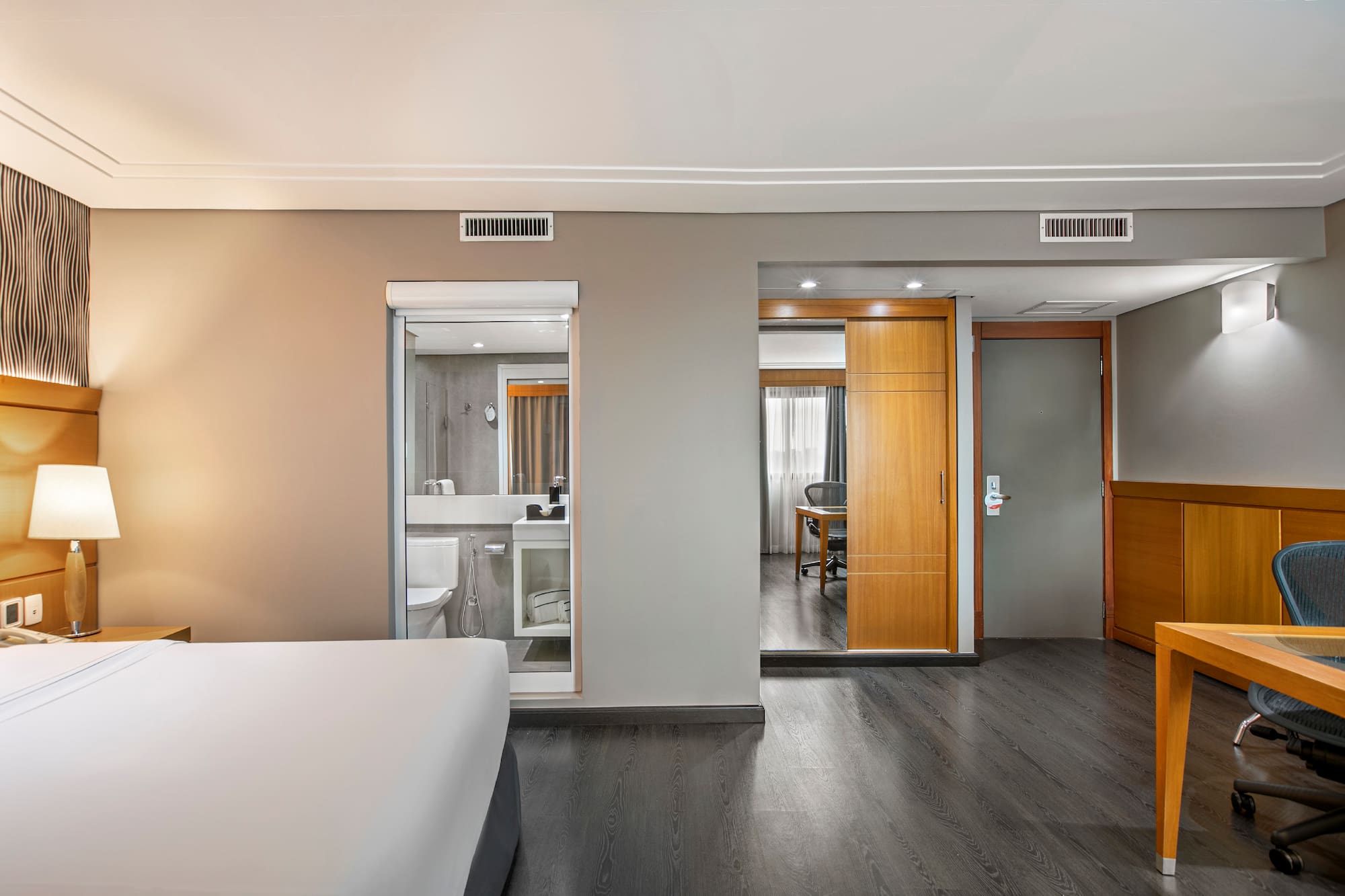 a bedroom with a wood floor and a wood door