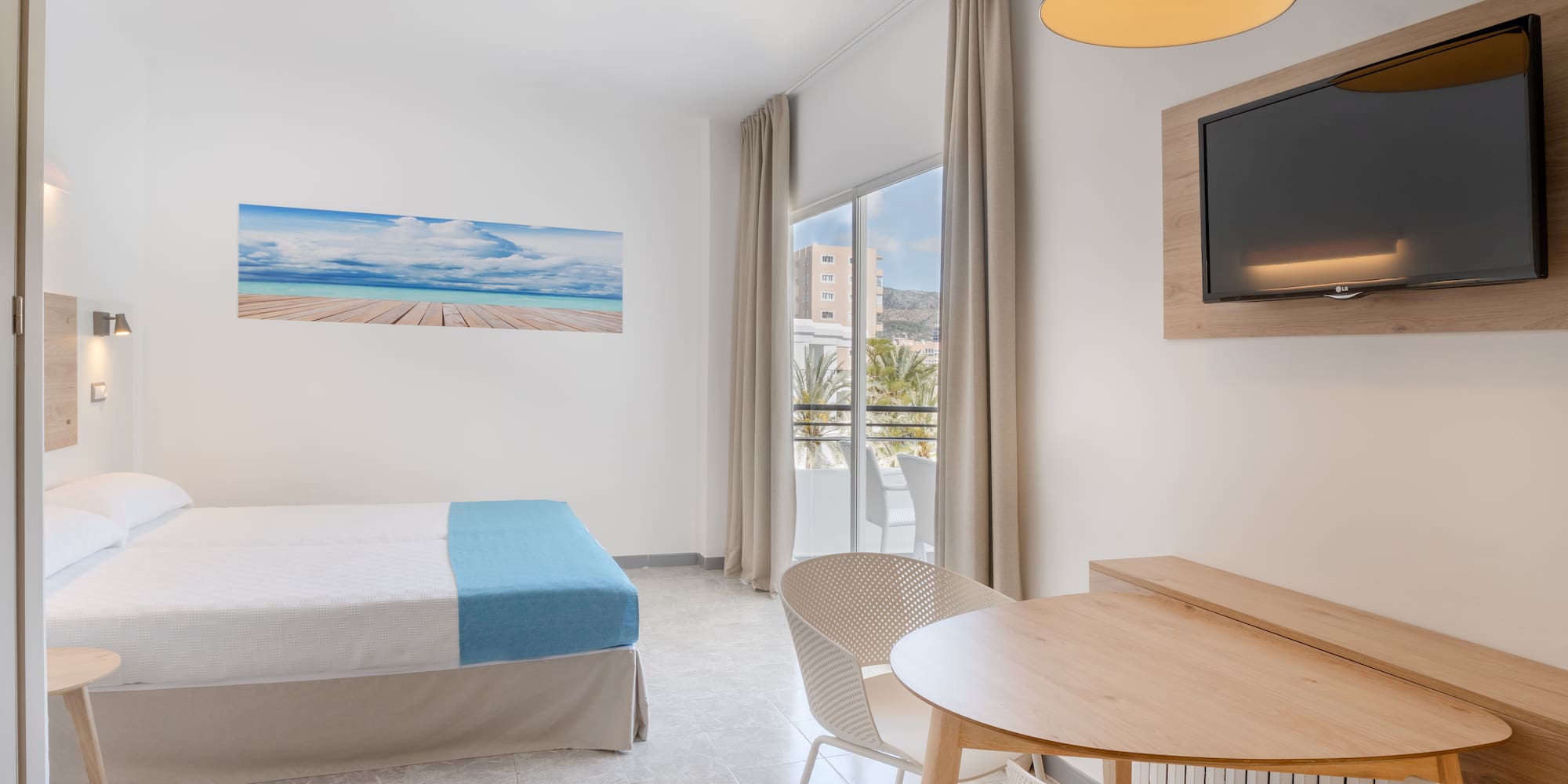 a room with a bed and a table and chairs