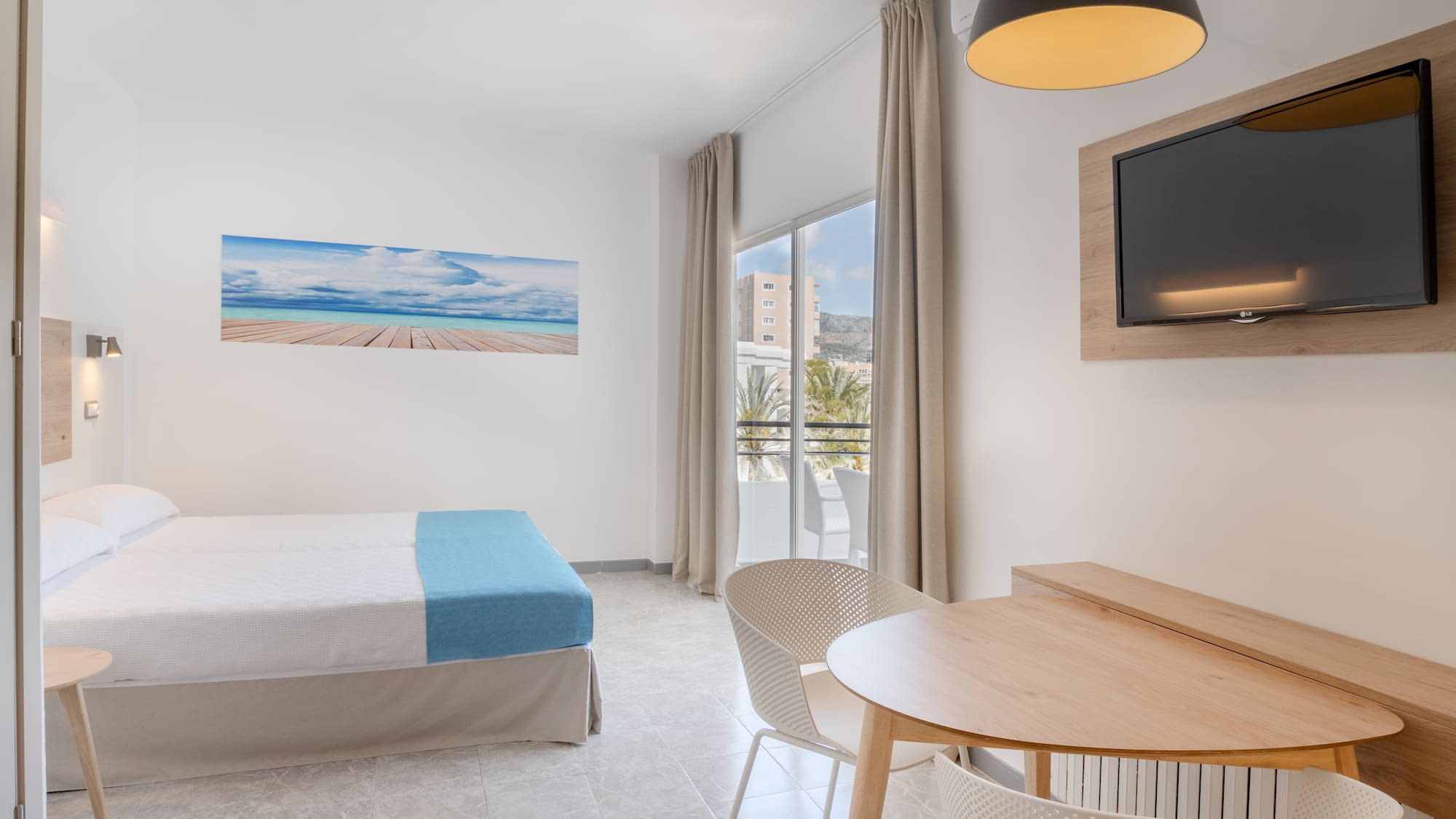 a room with a bed and a table and chairs