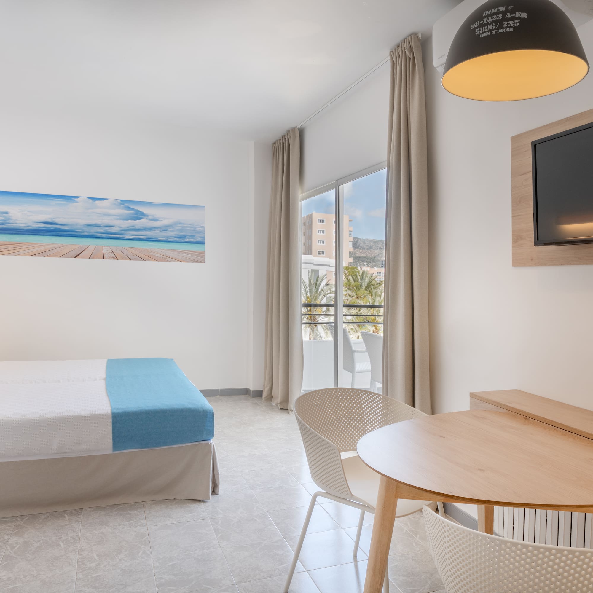 a room with a bed and a table and chairs