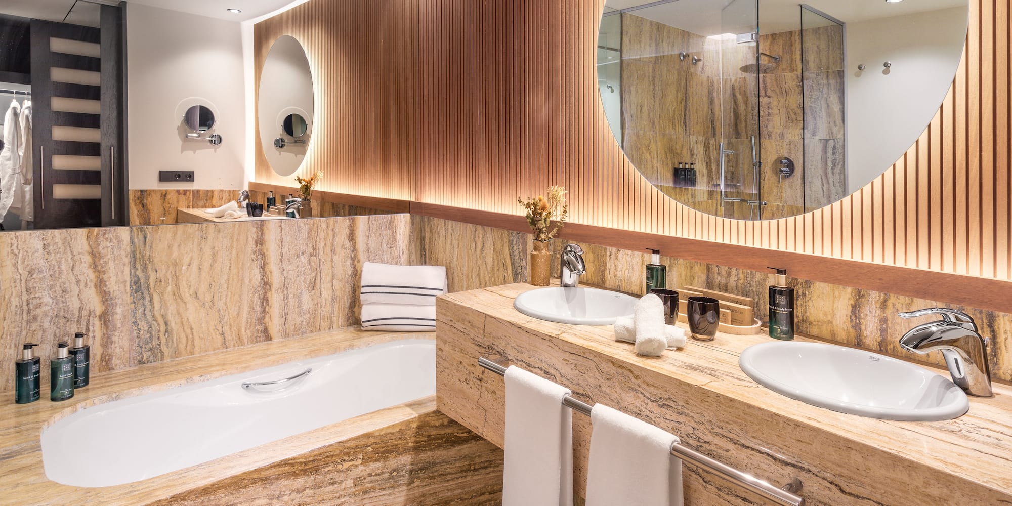 a bathroom with marble countertops and a round mirror
