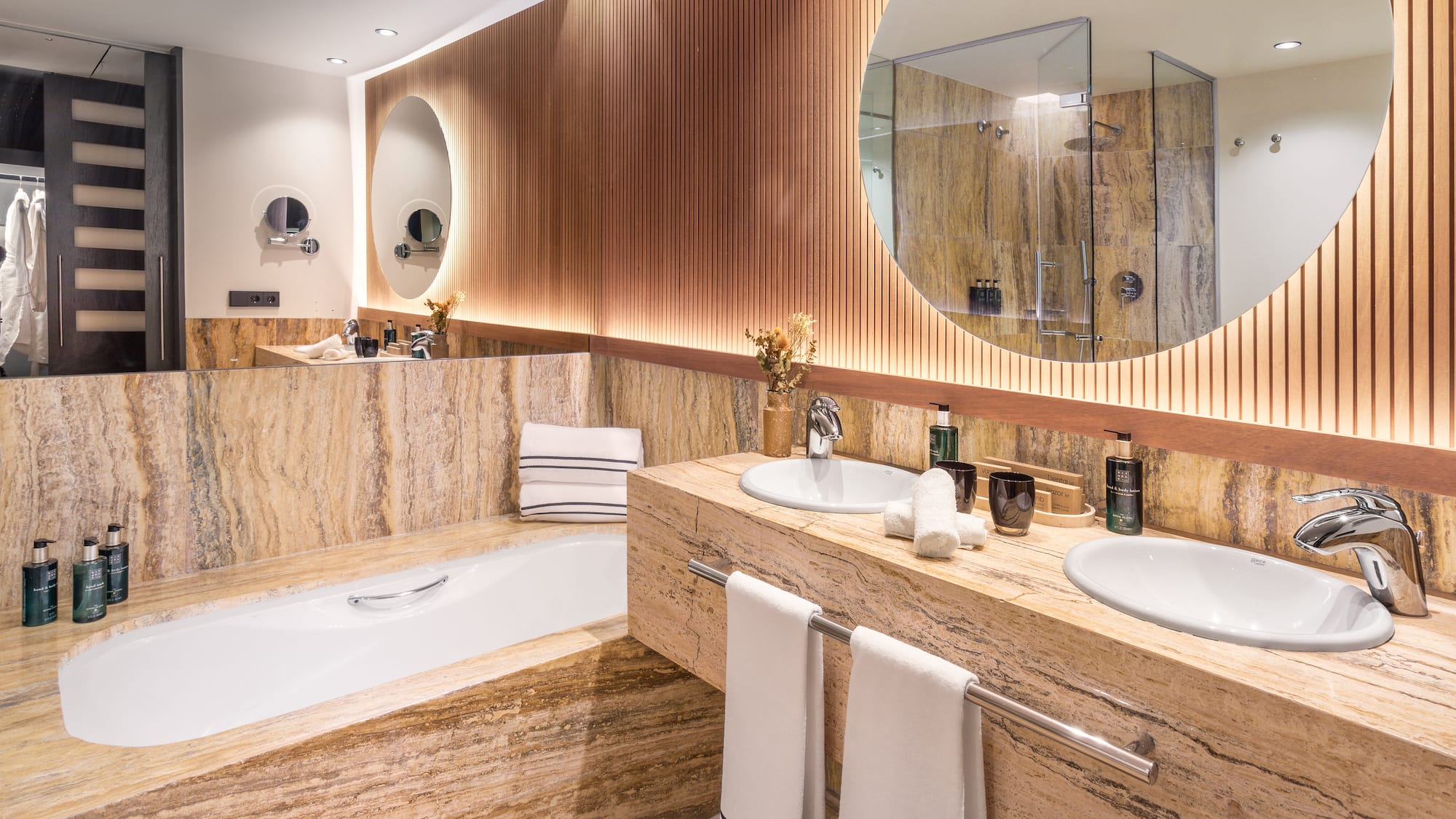a bathroom with marble countertops and a round mirror