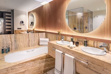 a bathroom with marble countertops and a round mirror