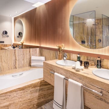a bathroom with marble countertops and a round mirror