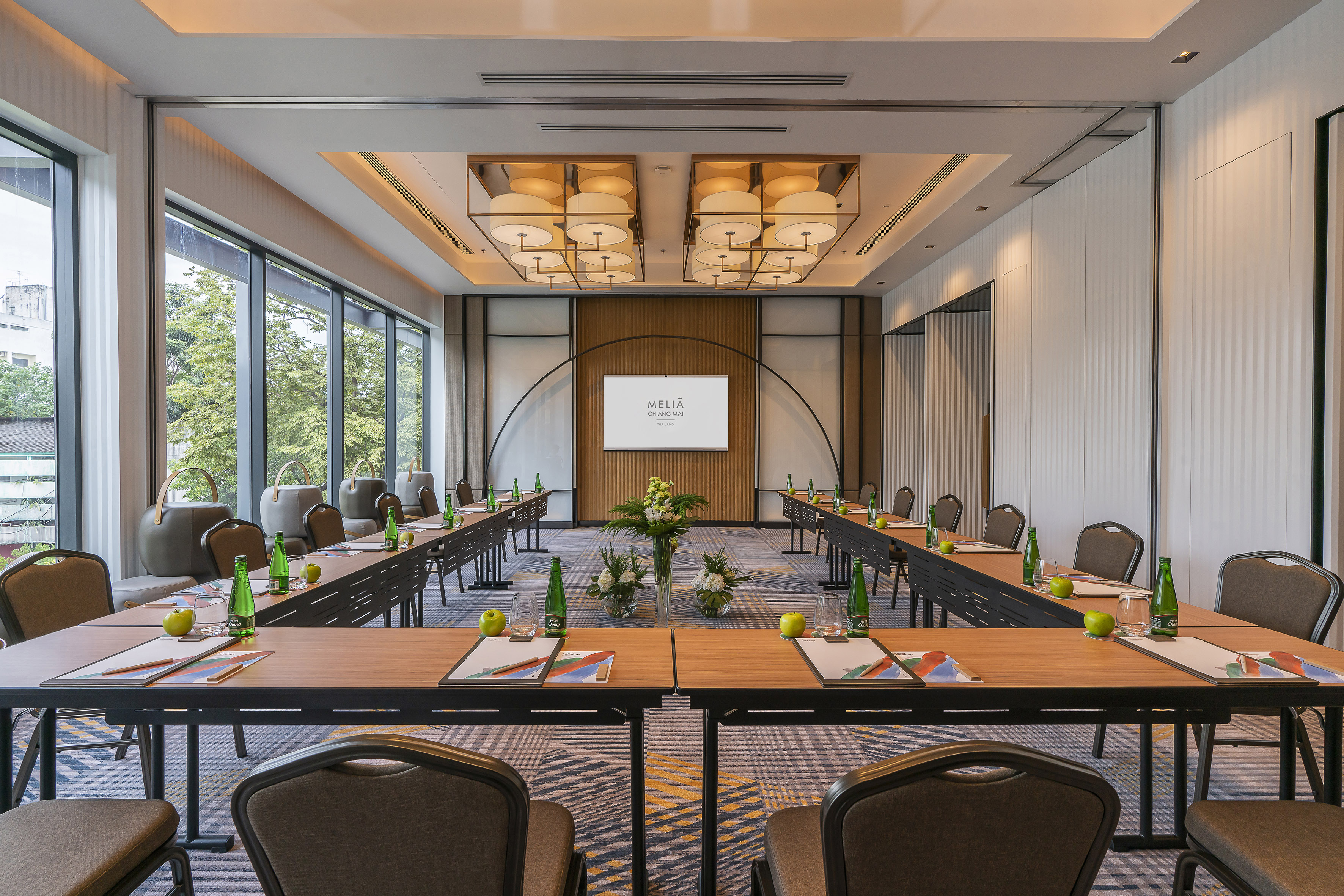 Modern U-shaped conference room with Melia Chiang Mai screen and large windows.