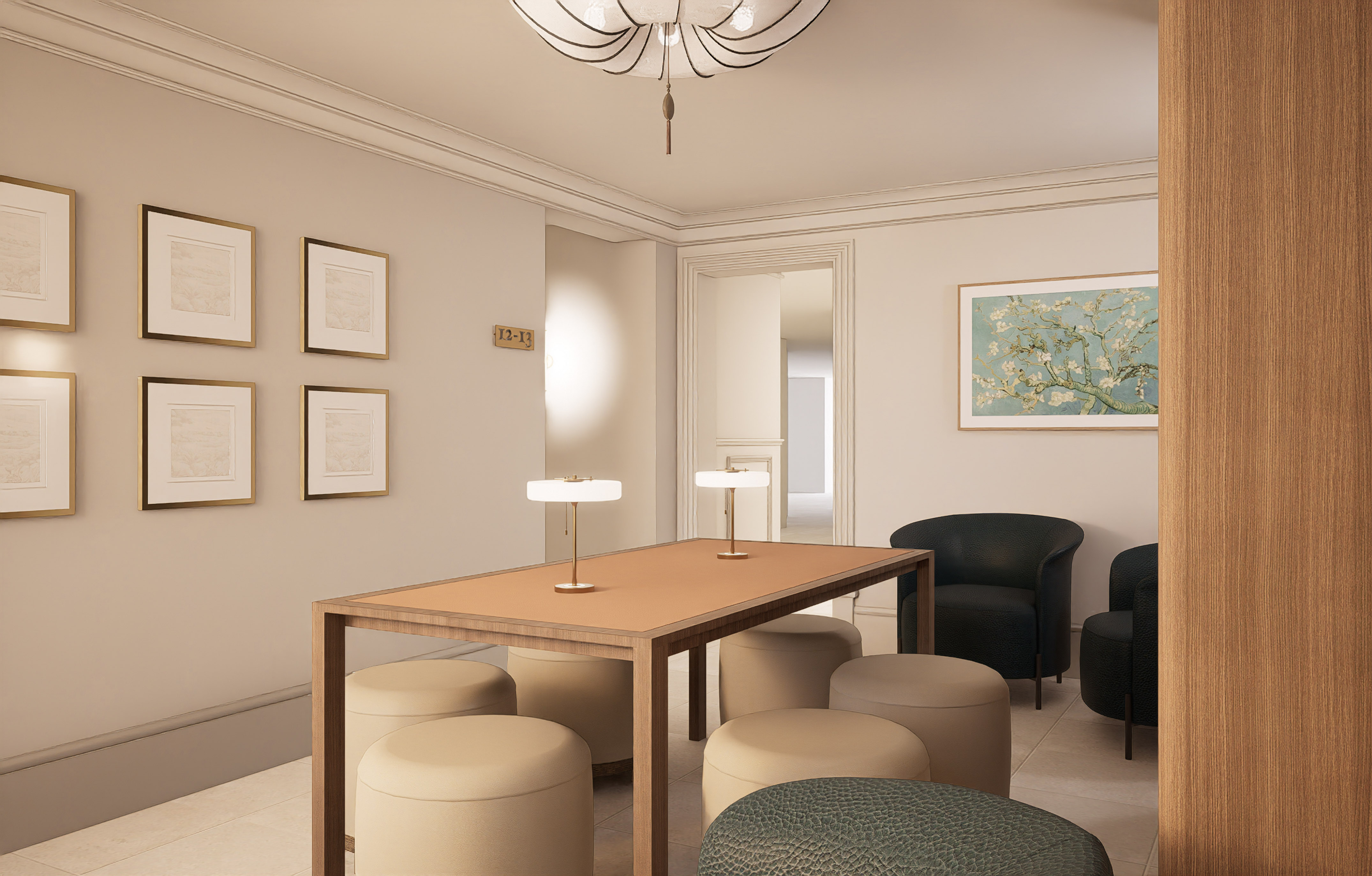 Elegant hotel lobby with meeting table, upholstered ottomans, black armchairs, and art.