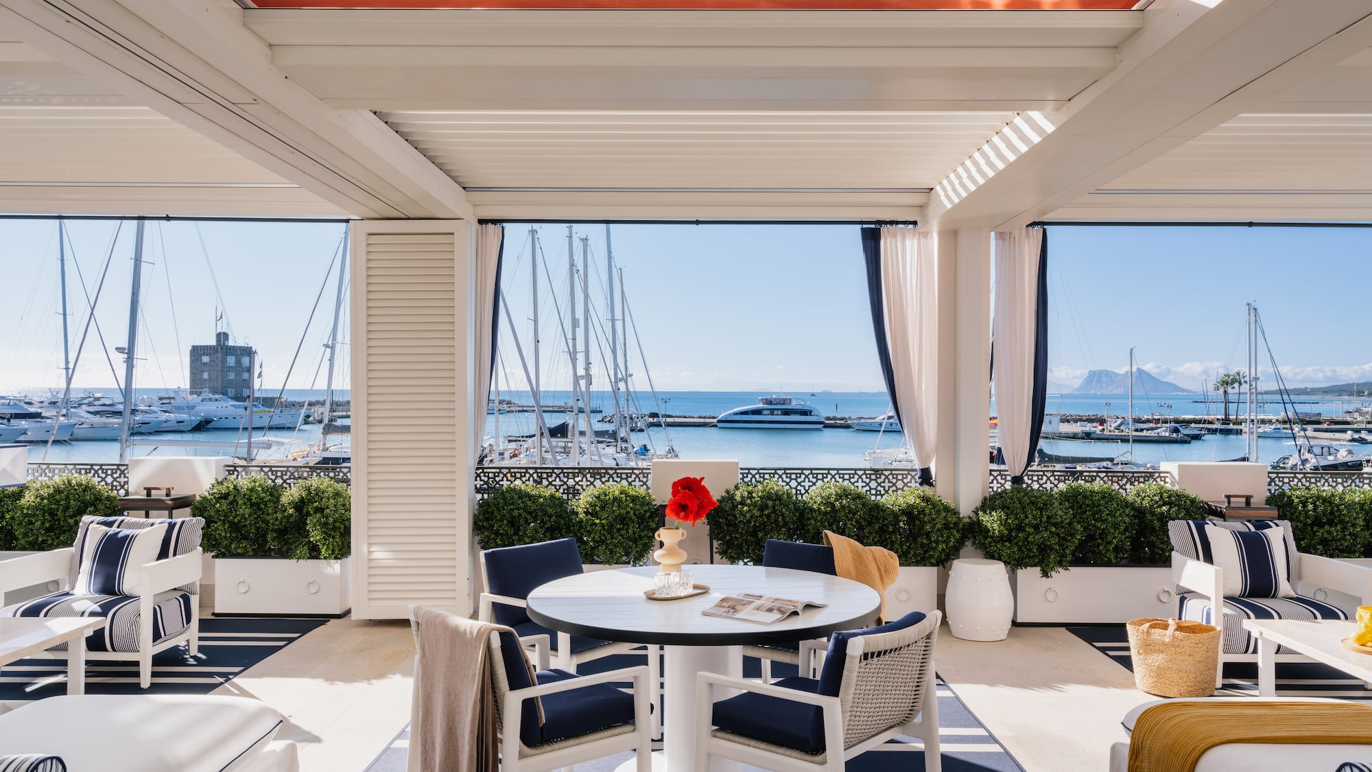 a patio with a table and chairs and a view of the water