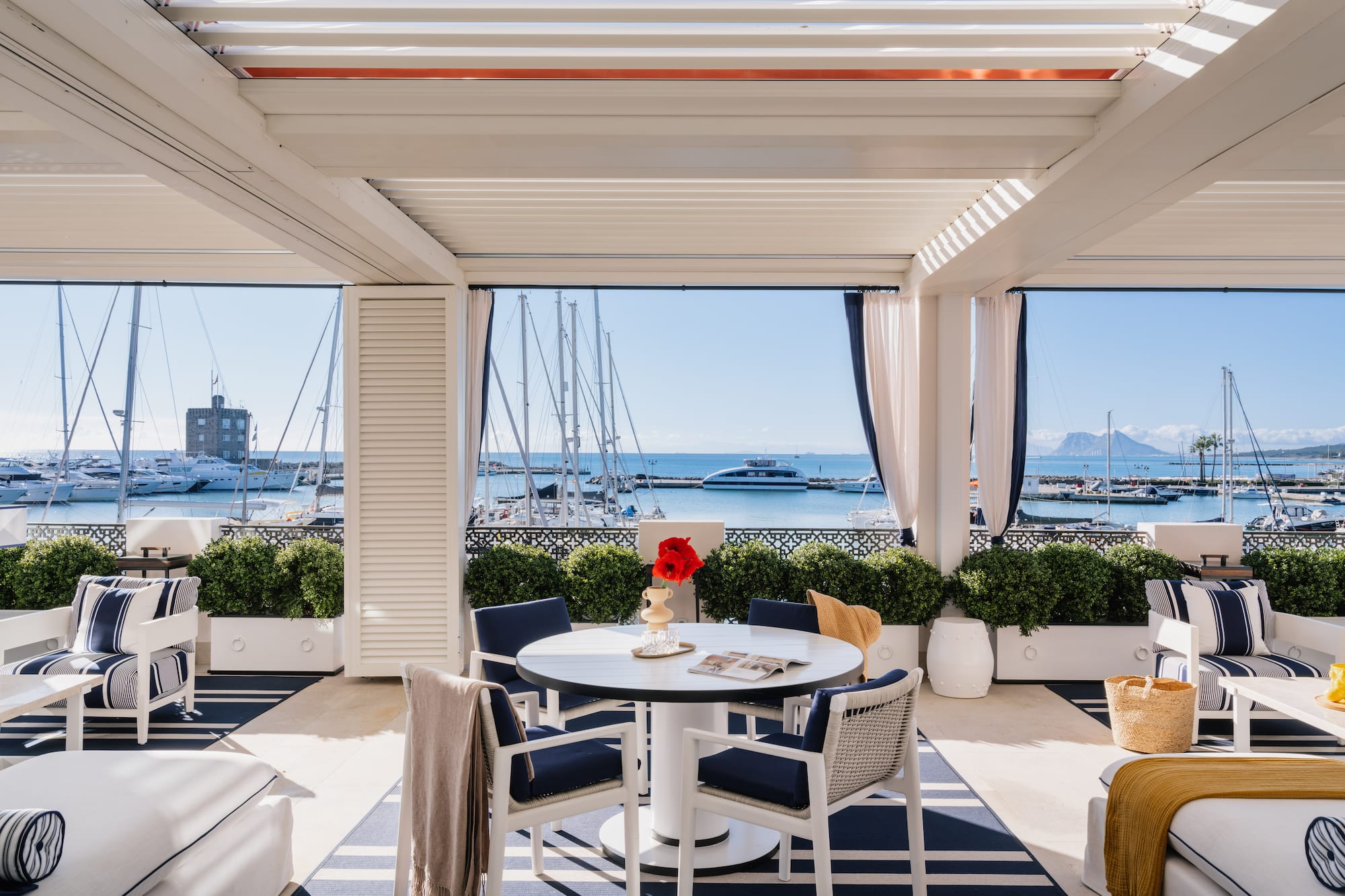 a patio with a table and chairs and a view of the water