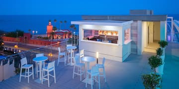 a rooftop bar with tables and chairs
